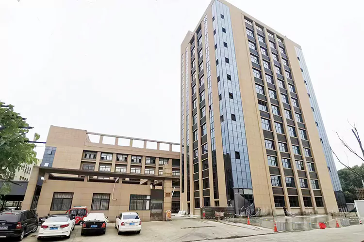 This picture shows the external perspective of the Baiquan factory, revealing a large workshop, a building, and a security guard room