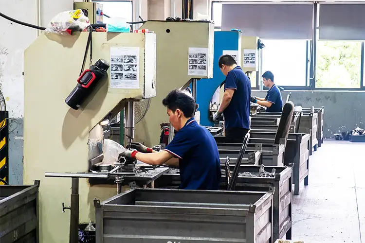 The picture shows workers from BAIQUAN factory operating a hydraulic press to make PTO pipes