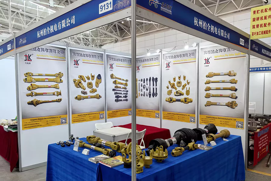 The picture shows a photo of BAIQUAN's booth at SAME2024, showcasing PTO Shaft and related accessories including yokes, Tube, torque limiter, cardan joint, U-joint, safety shield, etc