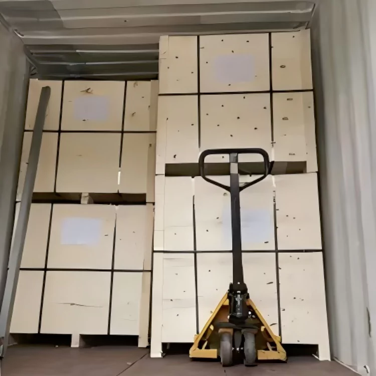 The picture shows the scene of workers using forklifts to load wooden boxes into containers