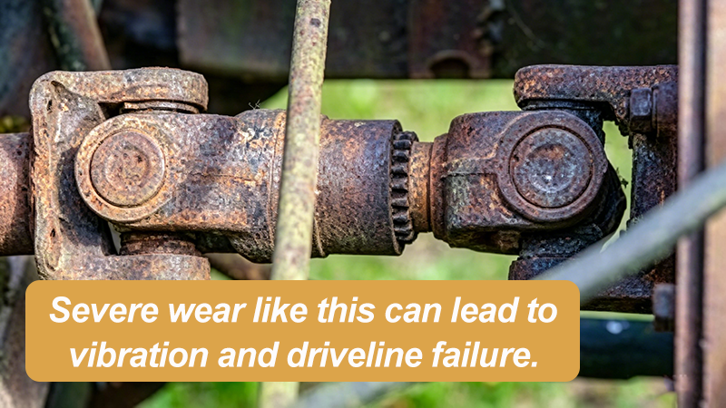 Worn PTO driveline universal joint showing rust and corrosion indicating splined yoke wear and replacement risk