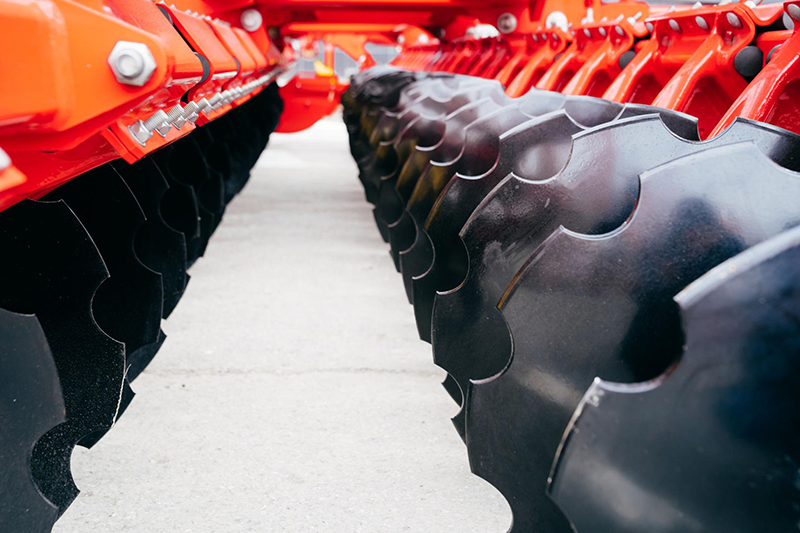 Agricultural disc harrow blades close-up showing smooth and notched steel discs for soil tillage