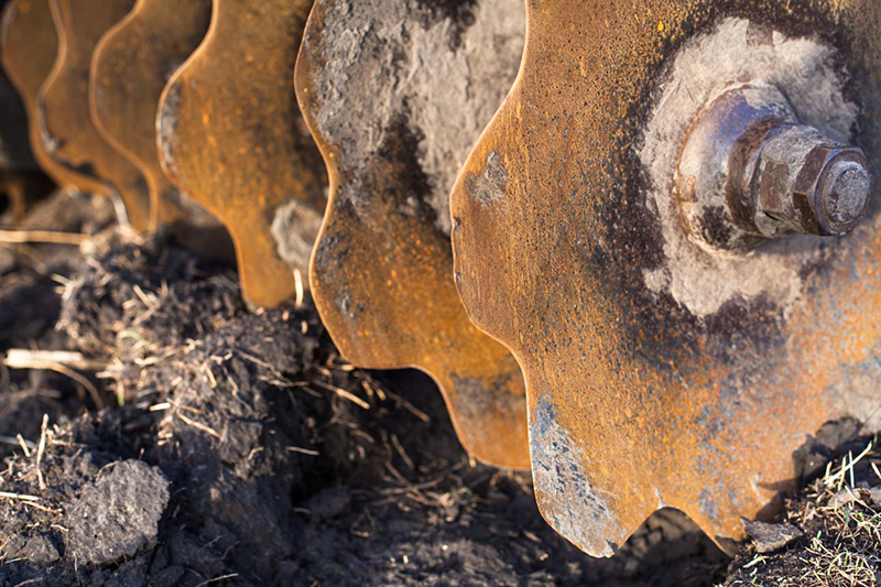 Worn and damaged agricultural blade showing cracks and edge wear for replacement