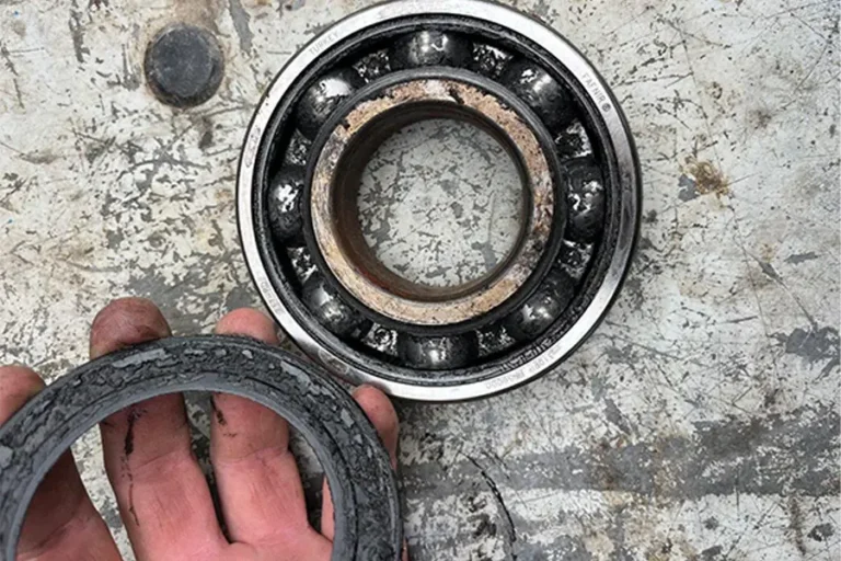 Damaged agricultural gearbox bearing showing signs of failure