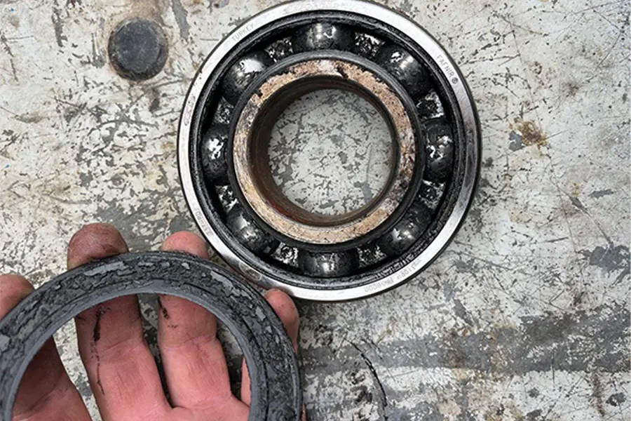 Damaged agricultural gearbox bearing showing signs of failure