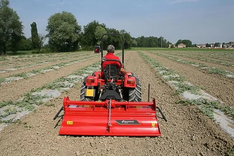 Tractor PTO rotary tiller working in the field